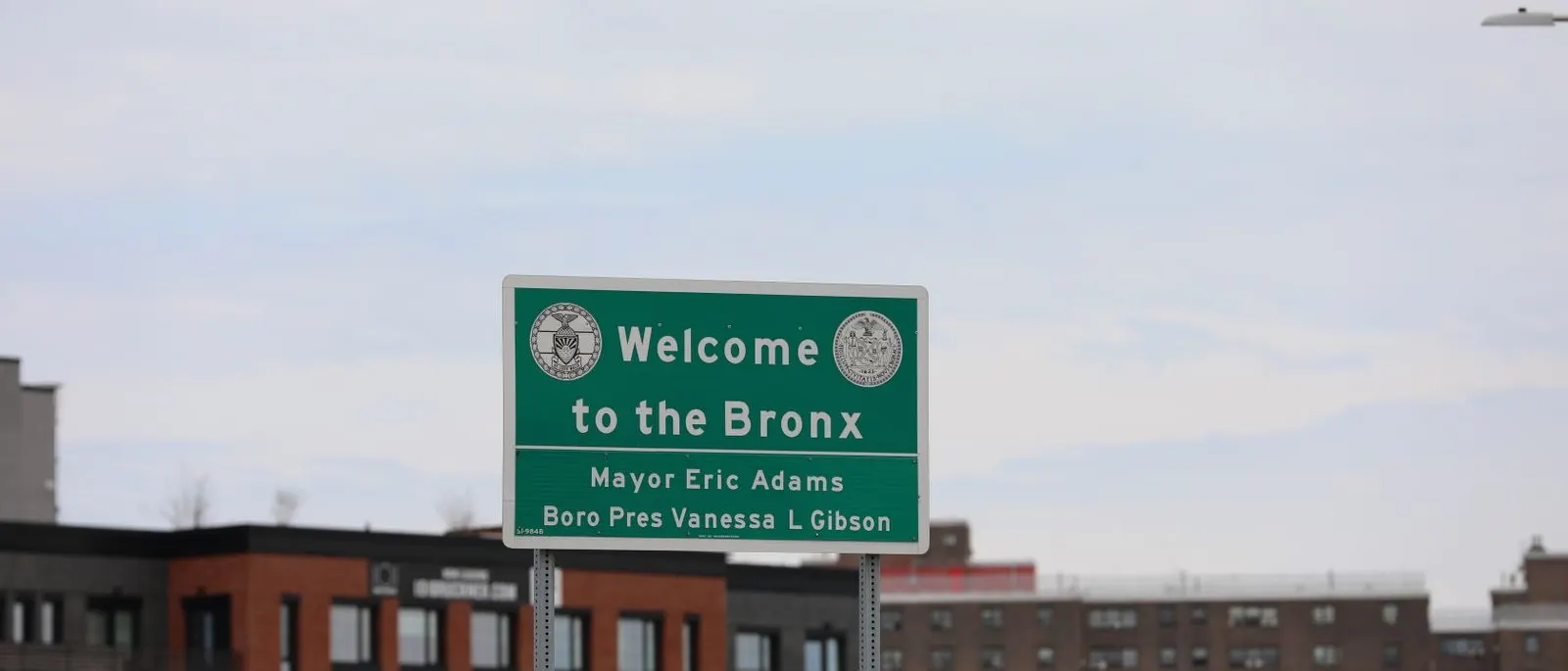 The Welcome to the Bronx sign above apartment buildings